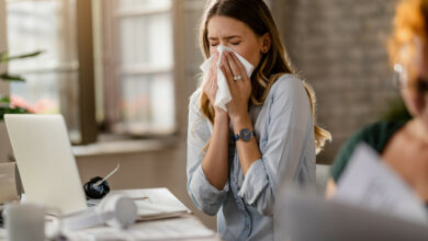 jeune-femme-d'affaires-malade-reniflant-un-tissu-en-travaillant-au-bureau