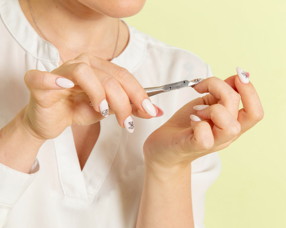 vue-devant-jeune-femme-attractive-chemise-blanche-fixant-les-ongles-de-la-surface-verte