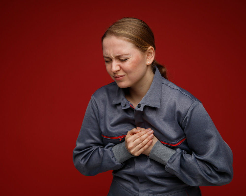 aching-young-blonde-female-engineer-wearing-uniform-keeping-hands-chest-with-closed-eyes