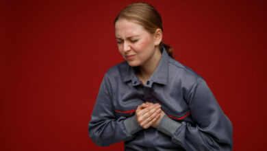 aching-young-blonde-female-engineer-wearing-uniform-keeping-hands-chest-with-closed-eyes