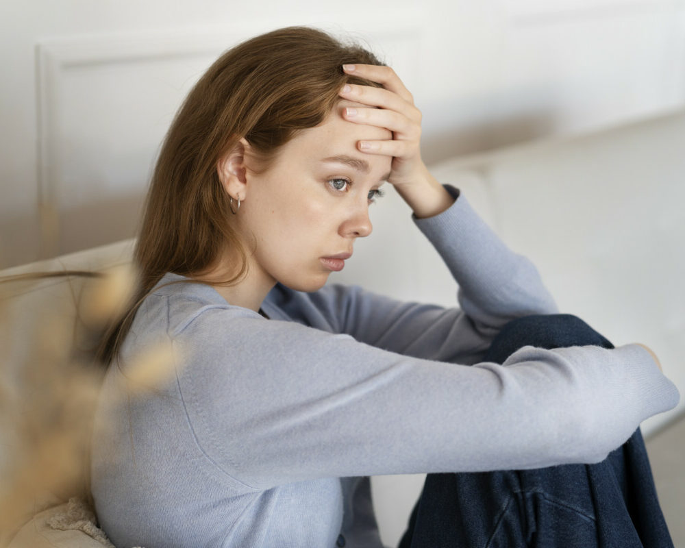 anxious-woman-sitting-couch-side-view