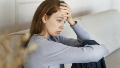 anxious-woman-sitting-couch-side-view