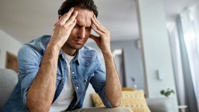 low-angle-view-distraught-man-holding-his-head-pain-while-sitting-living-room