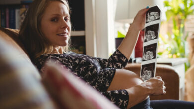 portrait-pregnant-woman-looking-sonography-living-room