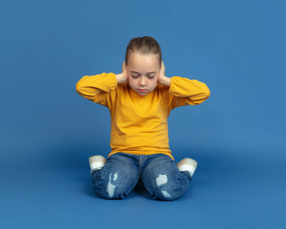 portrait-sad-little-girl-sitting-isolated-blue-studio-background-how-it-feels-be-autist-modern-problems-new-vision-social-issues-concept-autism-childhood-healthcare-medicine