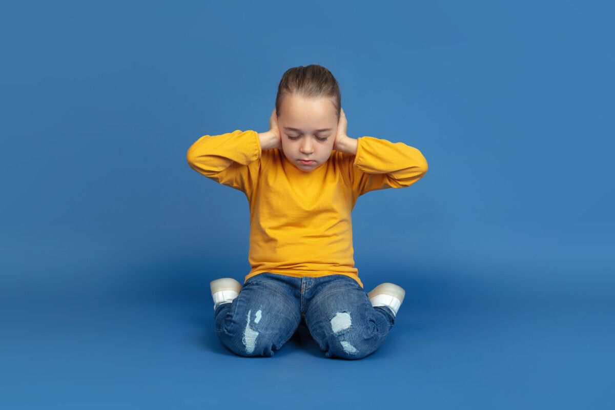 portrait-sad-little-girl-sitting-isolated-blue-studio-background-how-it-feels-be-autist-modern-problems-new-vision-social-issues-concept-autism-childhood-healthcare-medicine