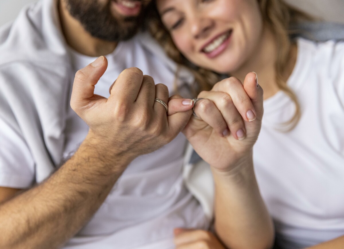 romantic-couple-locking-pinkies-sofa-home