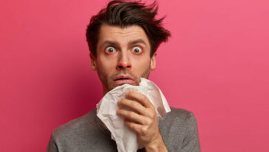 stunned-sick-man-has-flu-virus-allergy-respiratory-red-watery-eyes-blows-nose-tissue-finds-out-about-serious-disease-poses-pink-wall-health-medicine-symptoms-concept